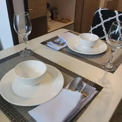 a table with two white plates and wine glasses at Blk Pod in Punta
