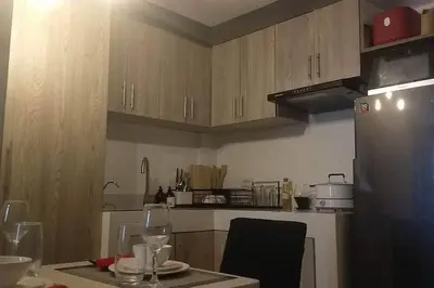 a kitchen with a refrigerator and a table with glasses at Blk Pod in Punta