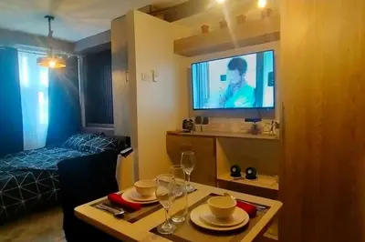 a living room with a table and a tv in a room at Blk Pod in Punta