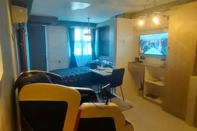 a room with a table and chairs and a television at Blk Pod in Punta