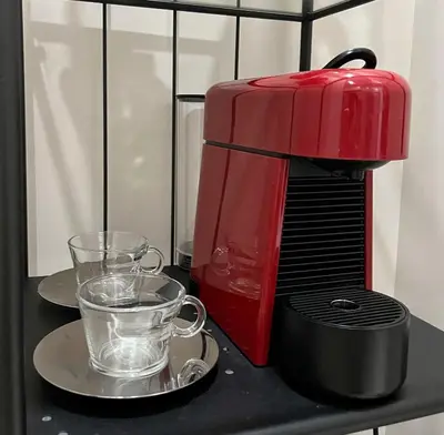 a red coffee maker and two glasses on a table at Uptown BGC Taguig - One Bedroom in Manila