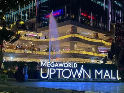 a fountain in front of a downtown mall at night at Uptown BGC Taguig - One Bedroom in Manila