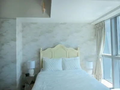 a bedroom with a white bed and a window at Uptown BGC Taguig - One Bedroom in Manila