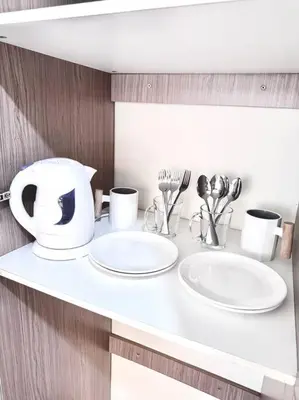 a white counter with two sinks and utensils on it at Arkisha’s Cozy Place in Manila