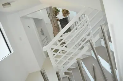 a white staircase with a tree in the middle at Date & Dine Resort in Antipolo
