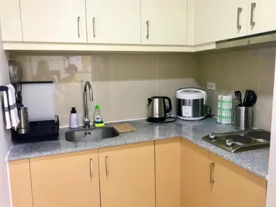 a kitchen counter with a sink and a microwave at New & Modern Cozy 1BR w/ Balcony@BGC, WiFi 300MBPS in Manila