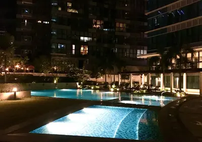 a swimming pool in a city at night at New & Modern Cozy 1BR w/ Balcony@BGC, WiFi 300MBPS in Manila