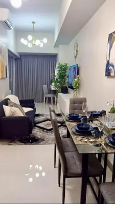 a living room with a dining table and a couch at New & Modern Cozy 1BR w/ Balcony@BGC, WiFi 300MBPS in Manila
