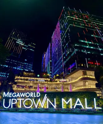 a lit up sign in front of a city at night at New & Modern Cozy 1BR w/ Balcony@BGC, WiFi 300MBPS in Manila