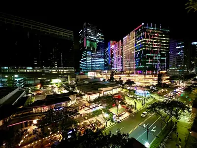 a city lit up at night with tall buildings at New & Modern Cozy 1BR w/ Balcony@BGC, WiFi 300MBPS in Manila