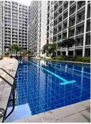 a large blue swimming pool in front of tall buildings at Shore 2 Staycation - Near Mall of Asia and Casinos in Manila