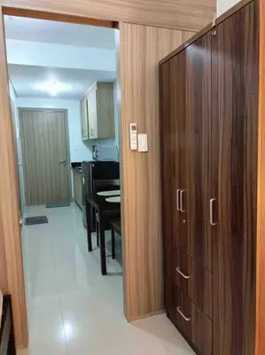 a kitchen with a wooden door and a dining room at Shore 2 Staycation - Near Mall of Asia and Casinos in Manila