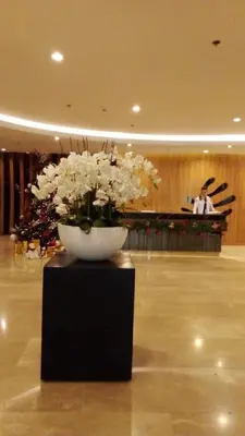 a vase with white flowers on a table in a lobby at The SPLENDOR Comfortable living by Awsom Phil in Manila