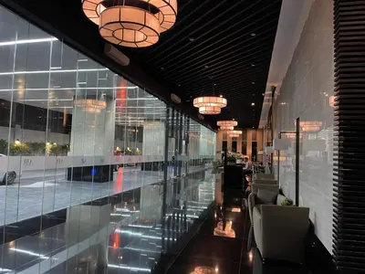 a lobby of a building with glass walls and chandeliers at Destina Stays@ Air Residences Makati, Metro Manila in Manila