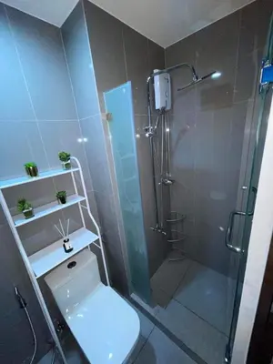 a bathroom with a shower with a toilet and a glass shower stall at Destina Stays@ Air Residences Makati, Metro Manila in Manila