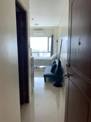 a room with a bedroom with a bed and a window at Makati Penthouse with Stunning City Skyline View in Manila