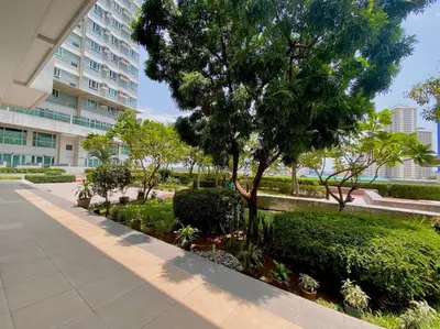 a tree and bushes in front of a building at Makati Penthouse with Stunning City Skyline View in Manila