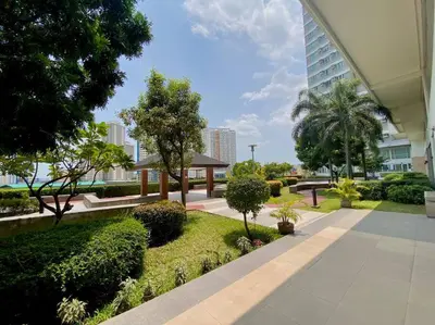 a park with trees and bushes and a building at Makati Penthouse with Stunning City Skyline View in Manila