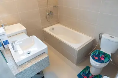 a bathroom with a sink and a toilet and a bath tub at A2J Luxury Uptown 3BR Suite Near Uptown Mall in Manila
