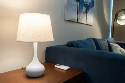 a lamp on a table next to a blue couch at A2J Luxury Uptown 3BR Suite Near Uptown Mall in Manila