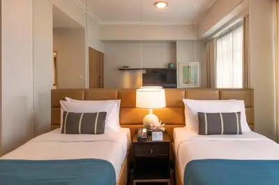 a hotel room with two beds and a lamp at Aruga Apartments by Rockwell Makati in Manila