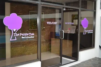 a glass door with purple trees on it at Purple Tree Bed & Breakfast in Manila