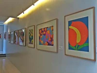 a row of paintings hanging on a wall at Purple Tree Bed & Breakfast in Manila