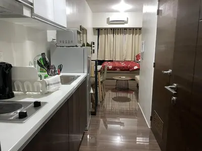 a kitchen with a sink and a refrigerator at Luxury Air Residences By Makati in Manila