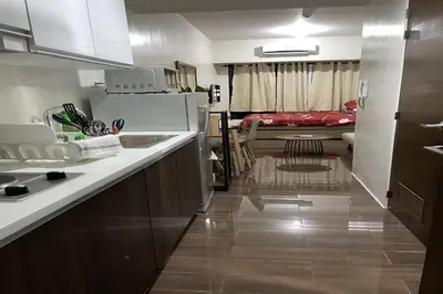 a kitchen with a sink and a refrigerator and a room at Luxury Air Residences By Makati in Manila