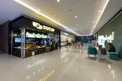 a store in a shopping mall with people walking around at Luxury Air Residences By Makati in Manila