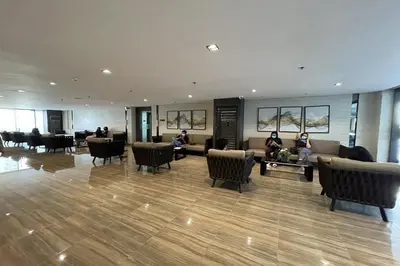 a lobby with people sitting on couches in a building at Luxury Air Residences By Makati in Manila