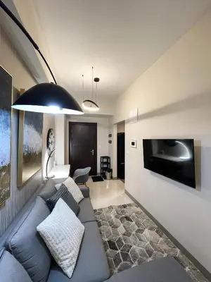 a living room with a blue couch and a tv at Amazing Unit and View in Uptown Parksuites BGC in Manila