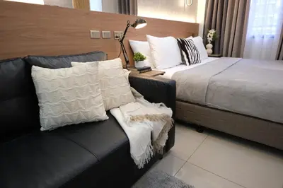 a hotel room with a bed and a couch at Staycation near Mall of Asia, Condotel with King Bed in Manila