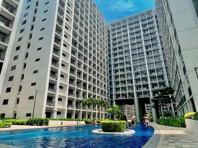 a large building with a fountain in front of it at Staycation near Mall of Asia, Condotel with King Bed in Manila