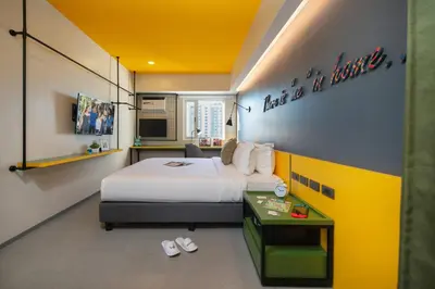 a hotel room with a bed and a table with slippers at lyf Malate Manila managed by The Ascott Limited in Manila