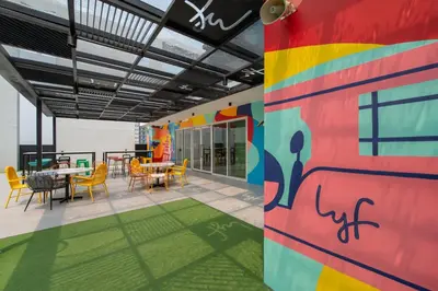a room with a table and chairs and a colorful wall at lyf Malate Manila managed by The Ascott Limited in Manila