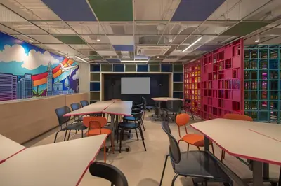 a classroom with tables and chairs and a projection screen at lyf Malate Manila managed by The Ascott Limited in Manila