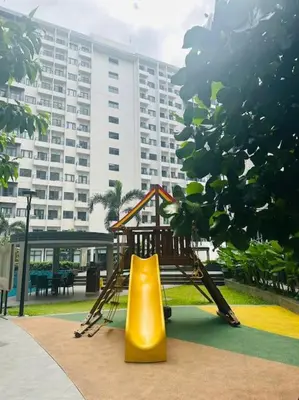 a playground with a slide next to a building at Jeced Condotel at Spring Residences near Airport in Manila