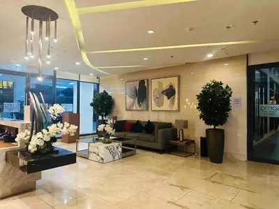 a lobby with a couch and flowers in a building at Jeced Condotel at Spring Residences near Airport in Manila
