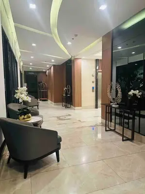 a lobby with chairs and tables in a building at Jeced Condotel at Spring Residences near Airport in Manila