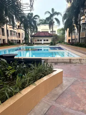 a swimming pool in a building with palm trees at Montecito HOME AWAY FROM HOME, across NAIA Terminal 3 in Manila