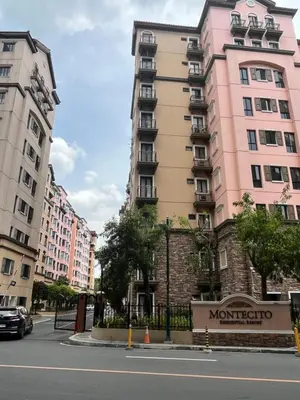 a tall pink building on a city street at Montecito HOME AWAY FROM HOME, across NAIA Terminal 3 in Manila