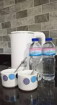 two bottles of water and two cups on a counter at Skyia's Pod a Premier Suite at Shore 2 Residences in Manila