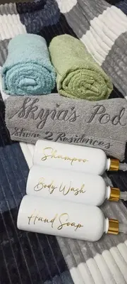 a pile of towels sitting on top of a bed at Skyia's Pod a Premier Suite at Shore 2 Residences in Manila