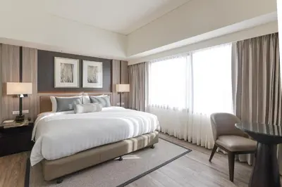 a hotel room with a large bed and a desk and a chair at Seda Nuvali Laguna near Tagaytay in Santa Rosa
