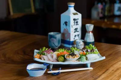 a plate of food sitting on a table with sushi at Microtel by Wyndham South Forbes near Nuvali in Santa Rosa