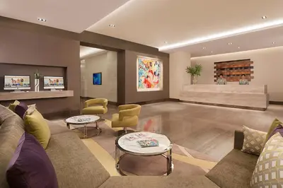 a living room with a couch and chairs at Citadines Salcedo Makati in Manila