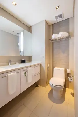 a white bathroom with a toilet and a sink at Citadines Salcedo Makati in Manila