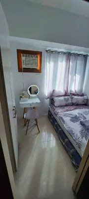 a bedroom with a bed with a desk and a bed sidx sidx sidx at Casa Lim SMDC Light Residences Tower 3 in Manila