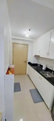 a kitchen with white cabinets and a sink and a door at Casa Lim SMDC Light Residences Tower 3 in Manila